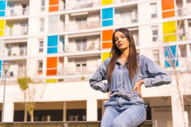 Siyah çantalı, maymun kovboylu, beyaz bir kız. Tatilde şehrin tadını çıkarmak, renkli bir evde oturan genç bir kızın yaşam tarzı.