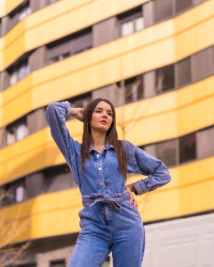 Sarı ve siyah bir evde maymun kovboyu olan beyaz bir kız. Tatilde şehrin tadını çıkarmak, genç bir kızın yaşam tarzı, modaya uygun poz vermek.