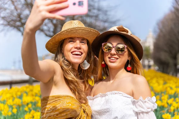 Przyjaciele Wakacjach Mieście Obok Pięknych Żółtych Kwiatów Robiąc Sobie Selfie — Zdjęcie stockowe