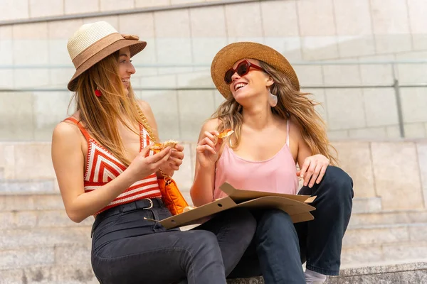 在城市里享受假期的女性朋友们正在吃披萨 年轻的游客们在吃披萨时面带微笑 — 图库照片