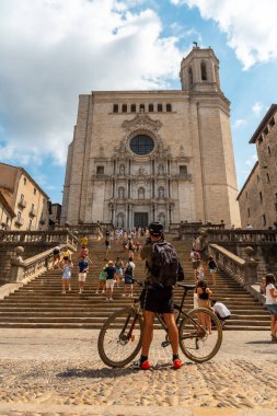 Ortaçağ 'ın Girona Katedrali' nde yaz tatili fotoğrafı çeken bir bisikletçi.