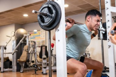 Spor salonunda, sağlıklı ve sağlıklı bir yaşam sürmek için ağırlık kaldıran beyaz bir adam.