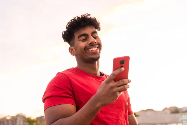 Jovem Árabe Com Camiseta Vermelha Pôr Sol Digitando Uma Mensagem — Fotografia de Stock