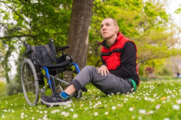 Porträtt Förlamad Ung Man Som Sitter Gräset Bredvid Rullstolen Tusensköna — Stockfoto