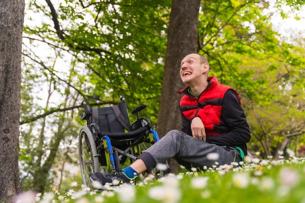 휘황찬란 휠체어 풀밭에 미소짓고 자연을 즐기는 마비된 청년의 — 스톡 사진