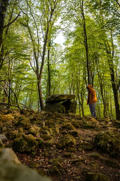 Bask ülkesindeki Aitzetako Txabala Dolmen 'in tepesinde bir adam. Errenteria, Gipuzkoa. dikey resim