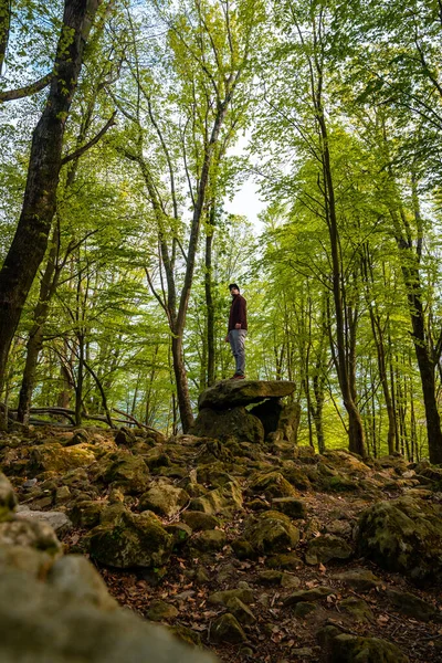 Bask ülkesindeki Aitzetako Txabala Dolmen 'in tepesinde bir adam. Errenteria, Gipuzkoa. dikey resim