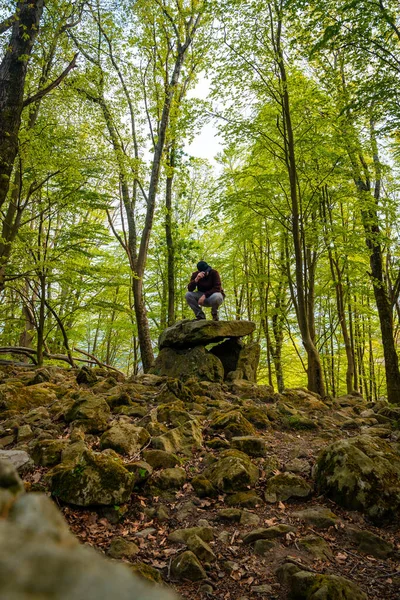 Bask ülkesindeki Aitzetako Txabala Dolmen 'de oturan bir adam. Errenteria, Gipuzkoa