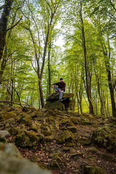 Bask ülkesindeki Aitzetako Txabala Dolmen 'de oturan bir adam. Errenteria, Gipuzkoa