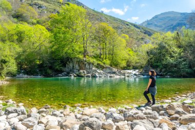 Baharda, Cangas de Onis yakınlarındaki Olla de San Vicente gölünde genç bir kadın. Asturyalar. İspanya