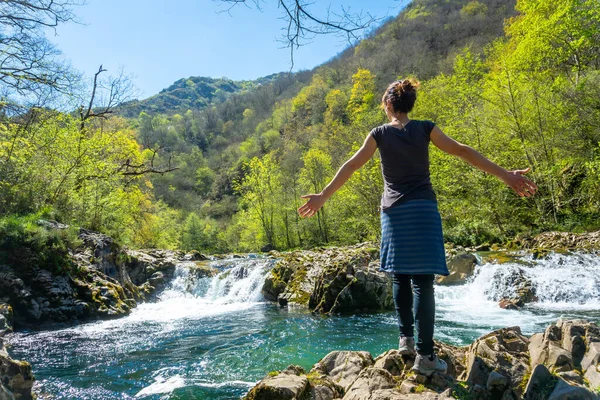 Cangas de Onis yakınlarındaki Tornin a la Olla de San Vicente arasında Sella nehrinin keyfini çıkaran genç bir kadın. Asturyalar. İspanya