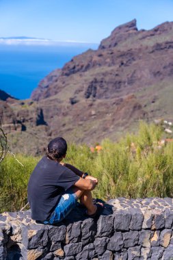 Tenerife, Kanarya Adaları 'nın kuzeyindeki Masca Dağı' na bakan şapkalı bir turist