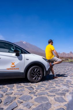 Tenerife, Kanarya Adaları 'ndaki Teide Doğal Parkı' ndaki Zapato de La Reina perspektifinde kiralık bir arabayla genç bir turist.