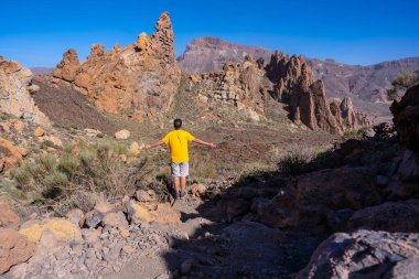Roques de Gracia ve Tenerife, Kanarya Adaları 'ndaki Teide' nin doğal alanındaki Roque Cinchado 'nun iniş yolunda genç bir adam.