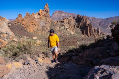 Roques de Gracia ve Tenerife, Kanarya Adaları 'ndaki Teide' nin doğal alanındaki Roque Cinchado 'nun iniş yolunda genç bir adam.