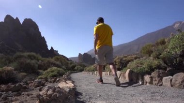 Tenerife, Kanarya Adaları 'ndaki Teide' nin doğal bölgesinde Roques de Gracia ve Roque Cinchado arasında yürüyen bir turist.