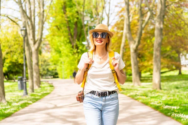 Blondynka Turystka Uśmiechnięta Kapeluszu Okularach Przeciwsłonecznych Spacerująca Wiosną Parku Mieście — Zdjęcie stockowe