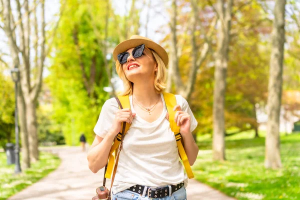 Блондинка Туристка Улыбается Шляпе Солнцезащитных Очках Гуляя Весной Парке Городе — стоковое фото