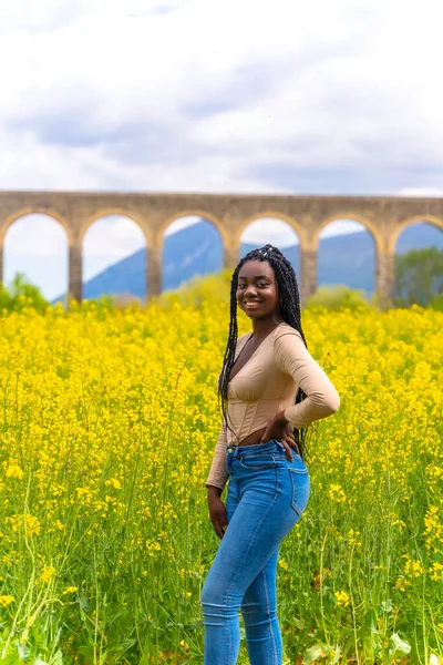 Posed Smiling Black Ethnic Girl Braids Traveler Field Yellow Flowers — Photo