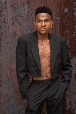 Metalik arka planda modaya uyan siyah etnik bir adam.