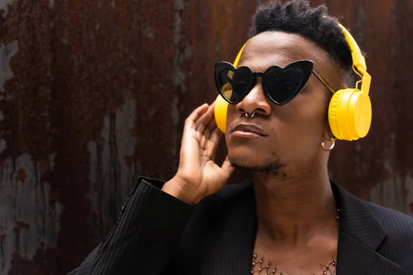 Czarny Etniczny Człowiek Słuchający Muzyki Bezprzewodowo Żółte Słuchawki Noszący Okulary — Zdjęcie stockowe