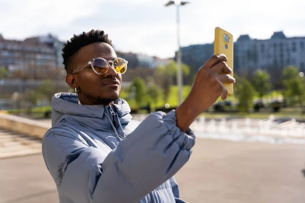 Černý Etnický Muž Telefonem Modrou Bundou Městě Bere Selfie — Stock fotografie
