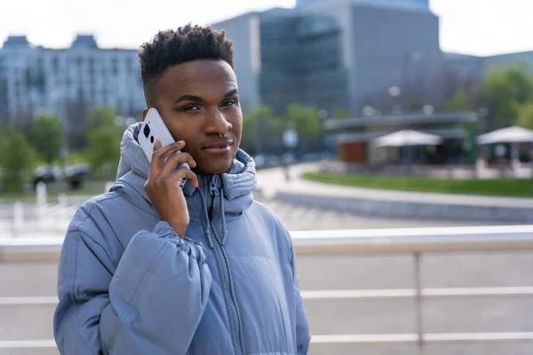 Černý Etnický Muž Telefonem Modrou Bundou Městě Mluví Telefonu — Stock fotografie