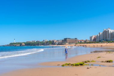 Biarritz, Lapurdi 'de sahilde yürüyen yaşlı bir kadın. Fransa, Güneybatı tatil köyü
