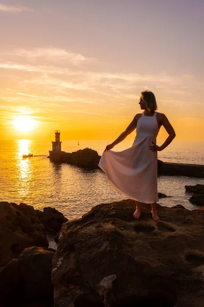 Uma Mulher Loira Vestido Branco Pôr Sol Lado Farol Mar — Fotografia de Stock