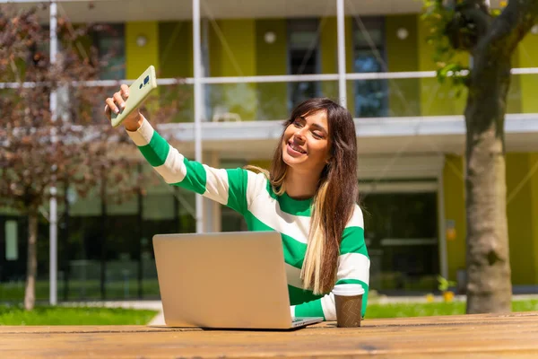 一个在自然界中与计算机一起工作的高加索女孩的肖像 带着手机自拍 — 图库照片