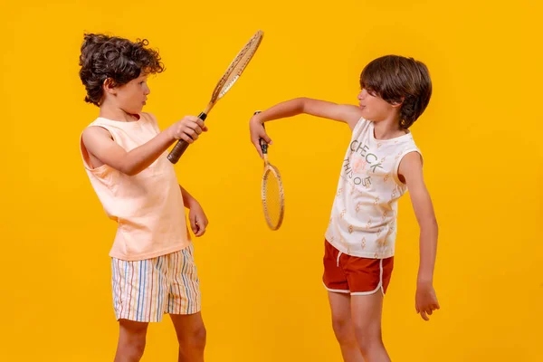 Два Брата Играют Теннис Веселятся Летом Желтый Фон — стоковое фото