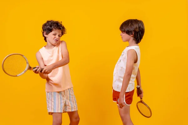 Dos Hermanos Jugando Tenis Divirtiéndose Verano Fondo Amarillo —  Fotos de Stock