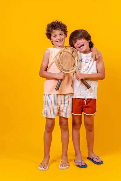 Retrato Dos Hermanos Jugando Tenis Vacaciones Verano Fondo Amarillo —  Fotos de Stock