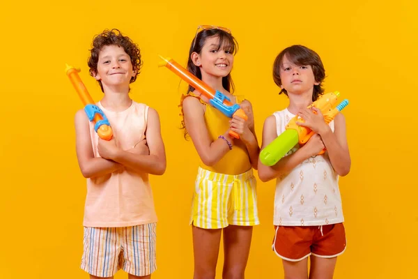 Kinder Mit Wasserpistolen Den Sommerferien Gelber Hintergrund — Stockfoto