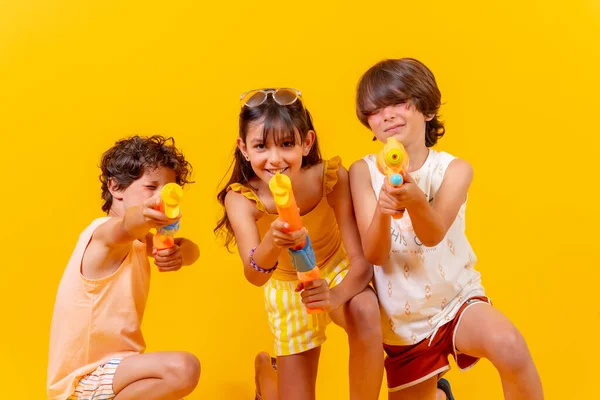 Діти Розважаються Водяними Гарматами Літніх Канікулах Жовтий Фон — стокове фото