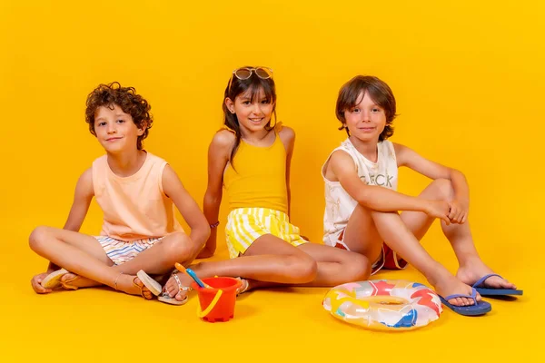 Дети Сидят Полу Наслаждаясь Праздниками Игрушками Желтый Фон — стоковое фото