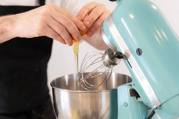 Evde Kırmızı Kadife Kek Pişiren Bir Adam Makineye Yumurta Ekleyerek — Stok fotoğraf