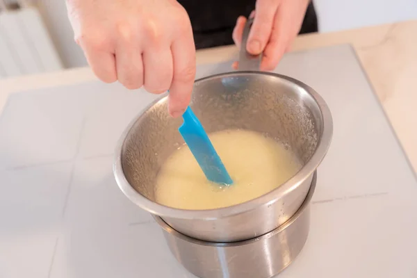 Hands of a man cooking a red velvet cake at home, cooking it in a bain-marie, work at home