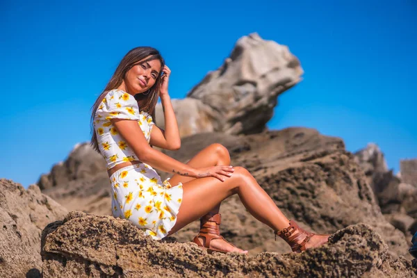 Brunette Model White Dress Beach Enjoying Summer Sitting Some Rocks — Zdjęcie stockowe