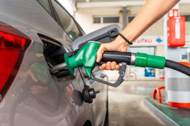 Benzin istasyonunda yakıt ikmali yapan kadın benzin fiyatları yüksek.