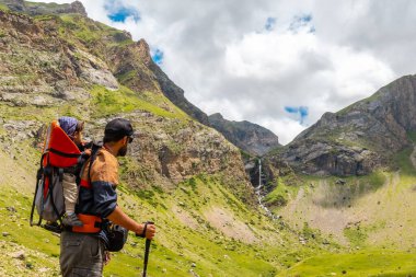A young man with his son at the Salto de Tendenera Waterfall in the Ripera Valley, Panticosa, Pyrenees