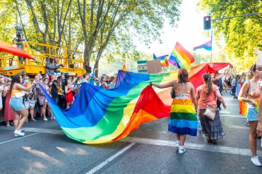 Madrid, İspanya: 9 Temmuz 2022: Madrid 'deki gay onur partisi ve geçit töreninde büyük bir bayrak taşıyan bazı gençler