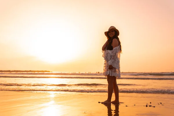 Muotokuva Naisesta Auringonlaskun Aikaan Valkoisessa Mekossa Hattu Päässä Kävelemässä Meren — kuvapankkivalokuva