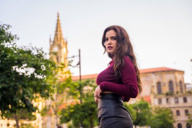 Kilisenin yanında deri etekli esmer bir Latin kadının portresi.