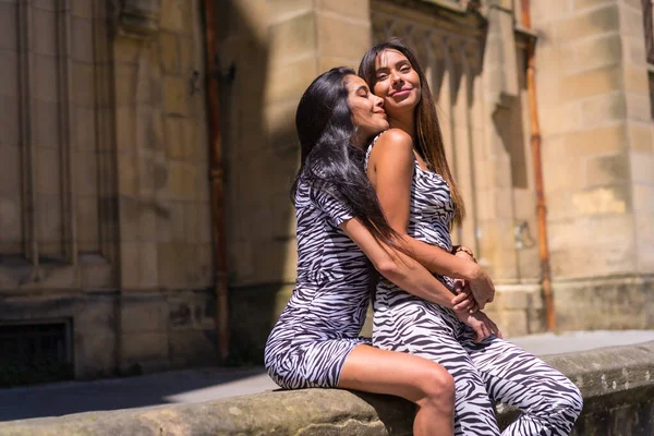 Two Sisters Hugging Each Other Zebra Print Jumpsuit Smiling City — 图库照片