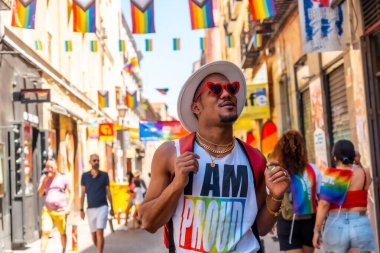 A gay black ethnicity man enjoying and smiling at the pride party, LGBT flag