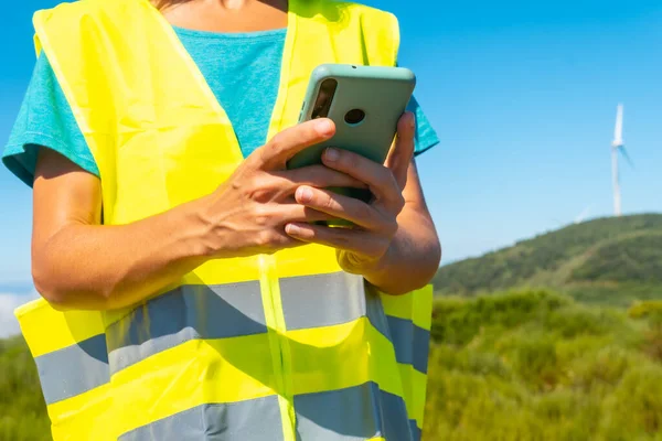 Hands of a working woman in a wind farm, green energy, technical review