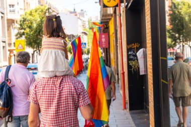 Families with children and with the lgbt flags in the streets at the pride party in Madrid