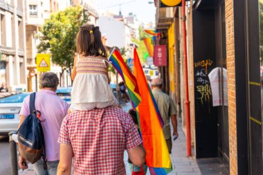 Families with children and with the lgbt flags in the streets at the pride party in Madrid