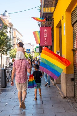 Families with children and with the lgbt flags in the streets at the pride party in Madrid
